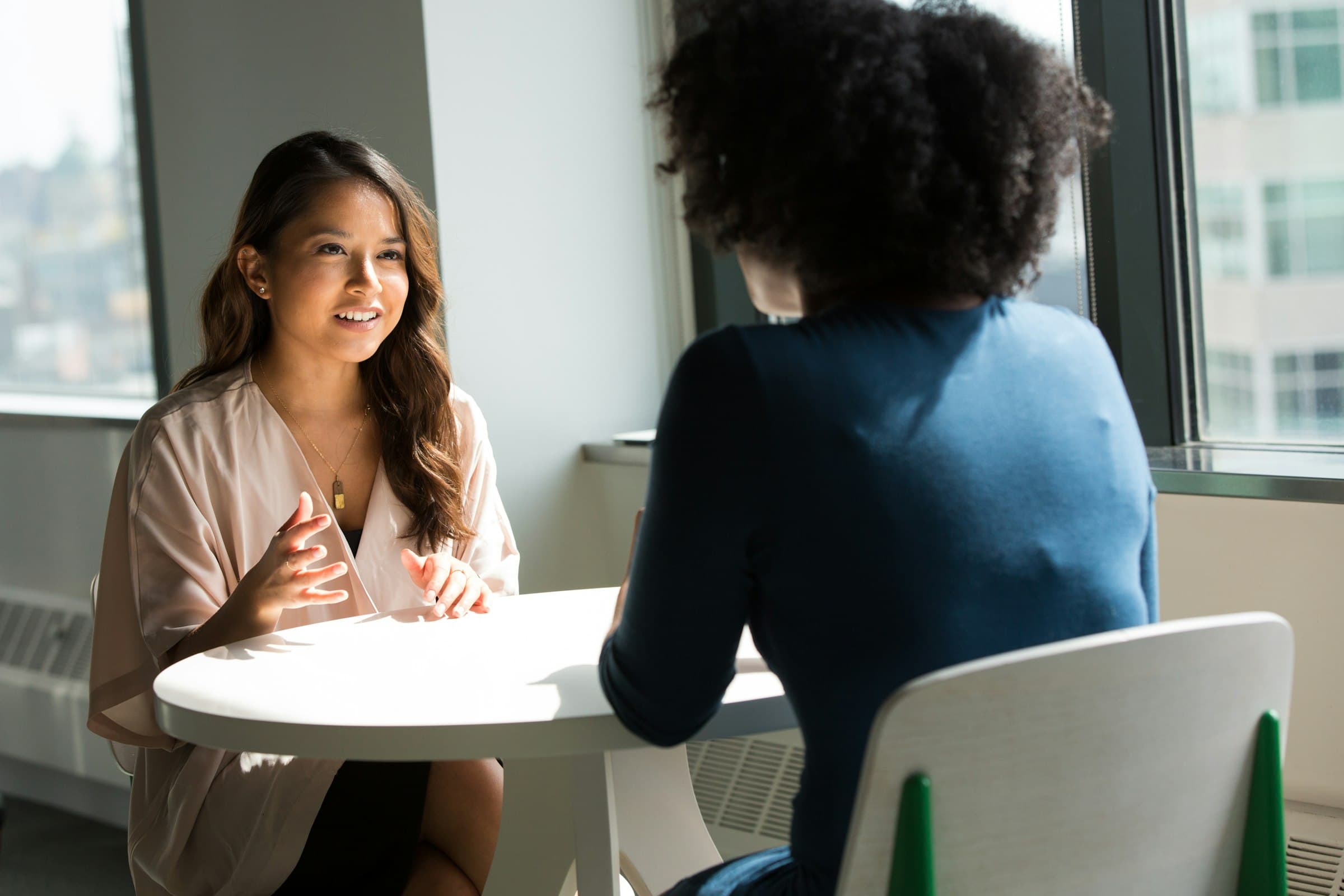 Two professionals in conversation in a bright office